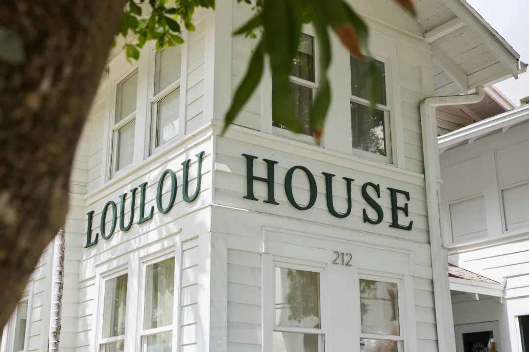 Close-up of the LOULOU HOUSE sign on the historic white façade