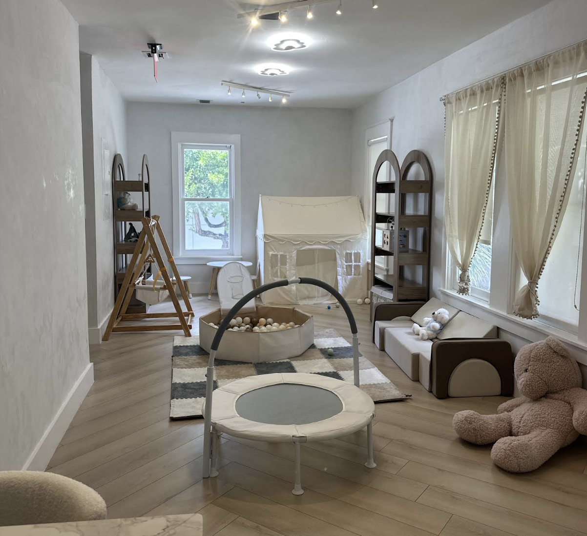 Wide room view with a trampoline, ball pit, and play tent
