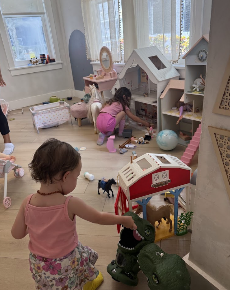 Children playing with dollhouses and farm toys in the Play Area