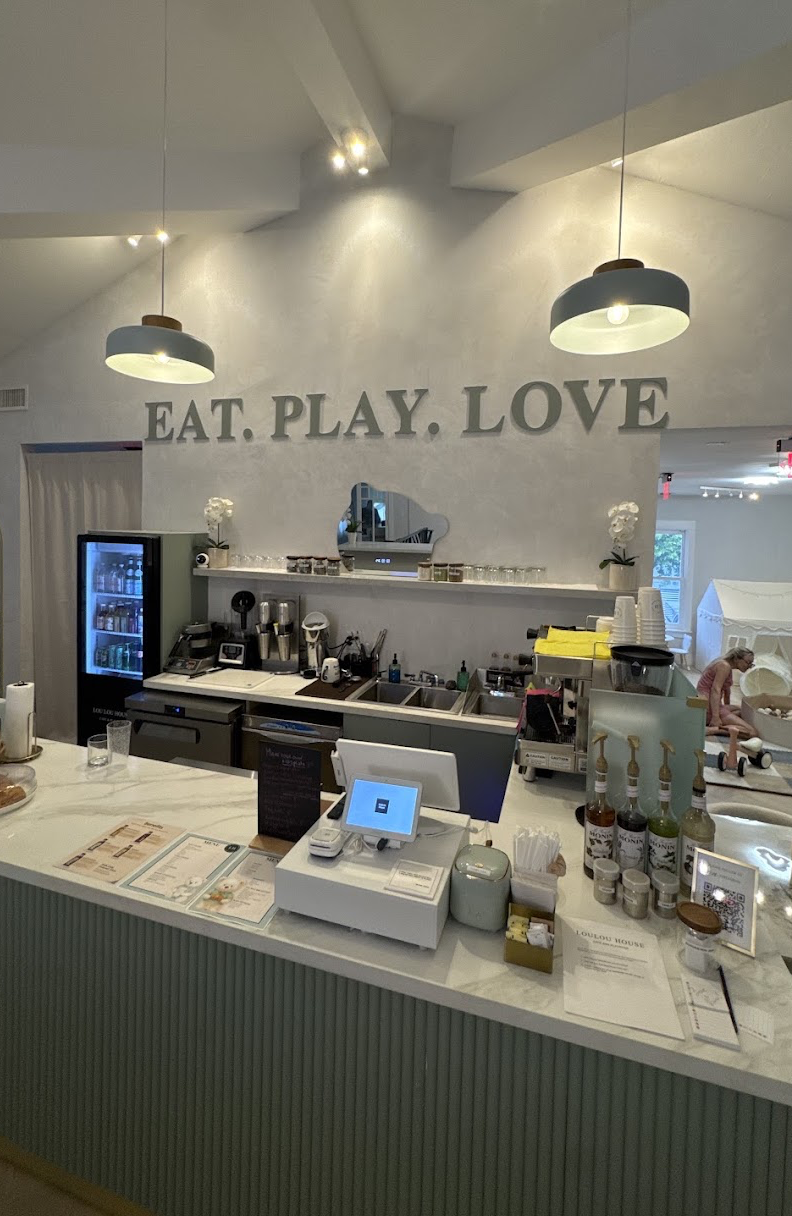 Cafe bar with 'Eat. Play. Love.' signage and espresso setup