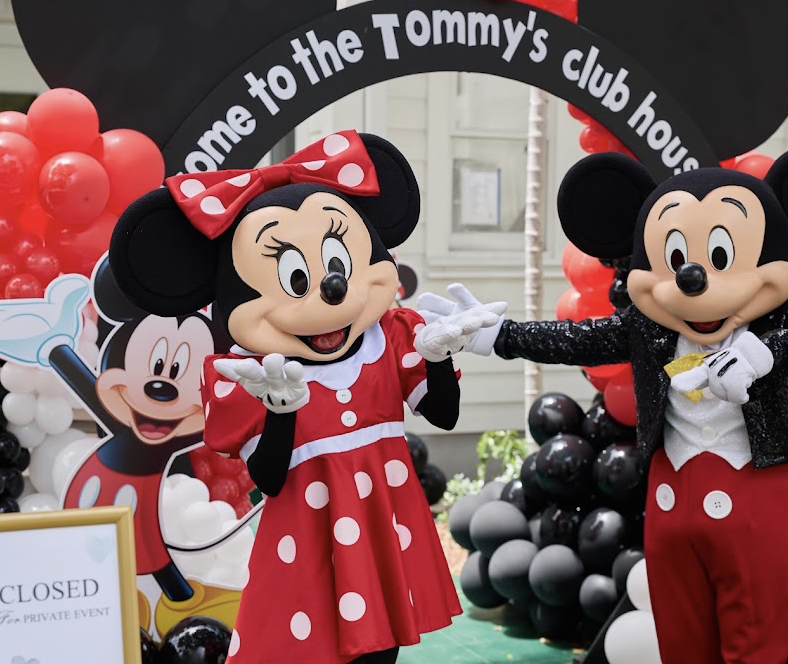 Mickey and Minnie Mouse characters welcoming guests to a birthday celebration