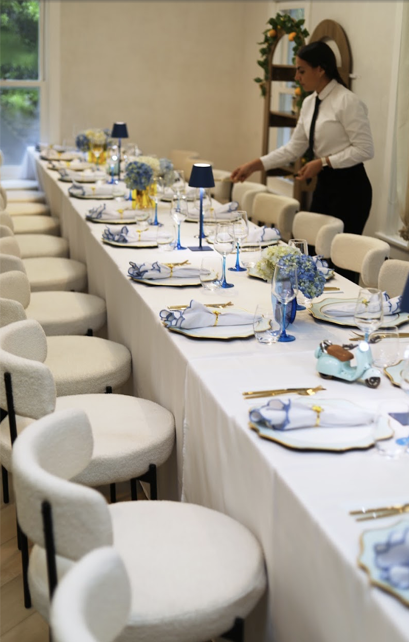 Long private event table set with blue accents and gold cutlery