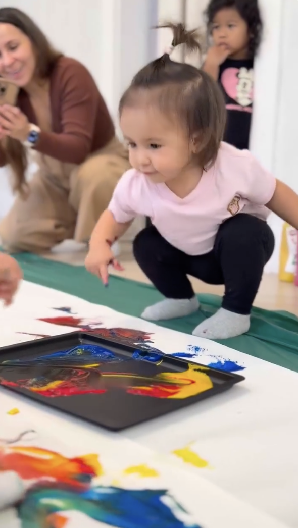 Toddler exploring paint on a sensory tray at LOULOU HOUSE