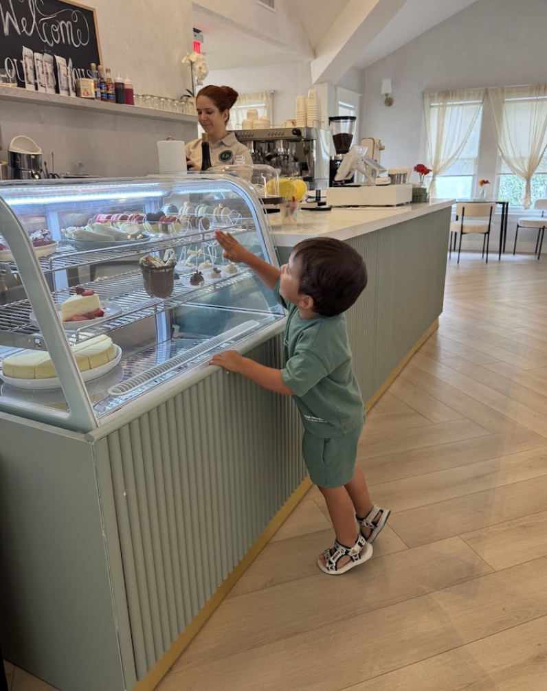 A child at the pastry display picking a dessert