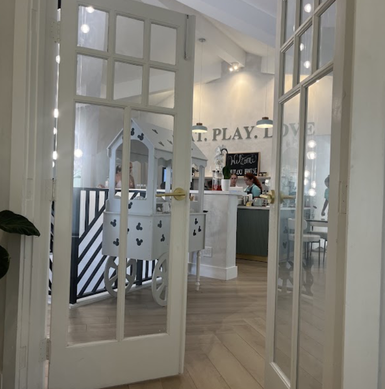 View through the French doors into the cafe with 'Eat. Play. Love.' signage