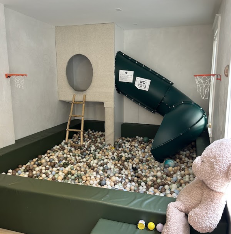Ball pit and green tube slide inside the Play Area