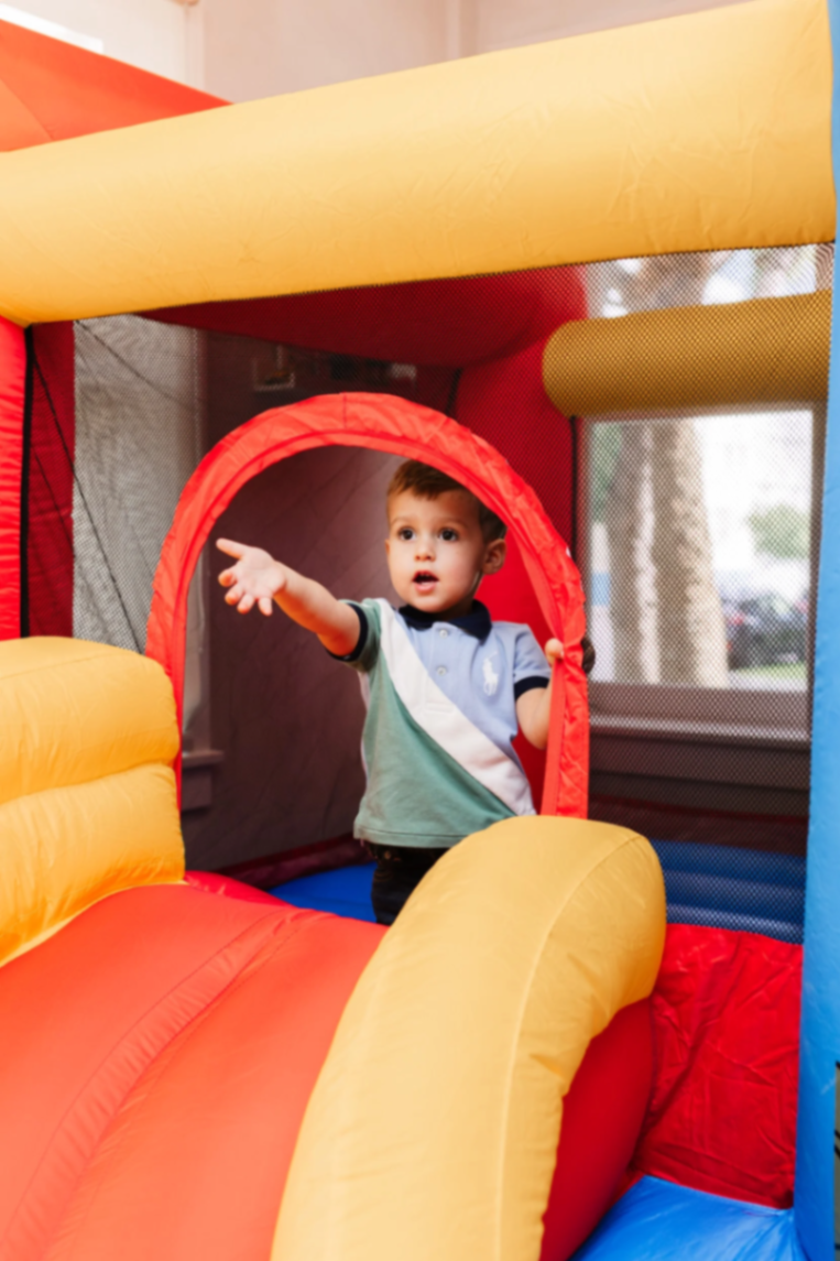 A toddler inside a colorful bounce house in the Play Room.
