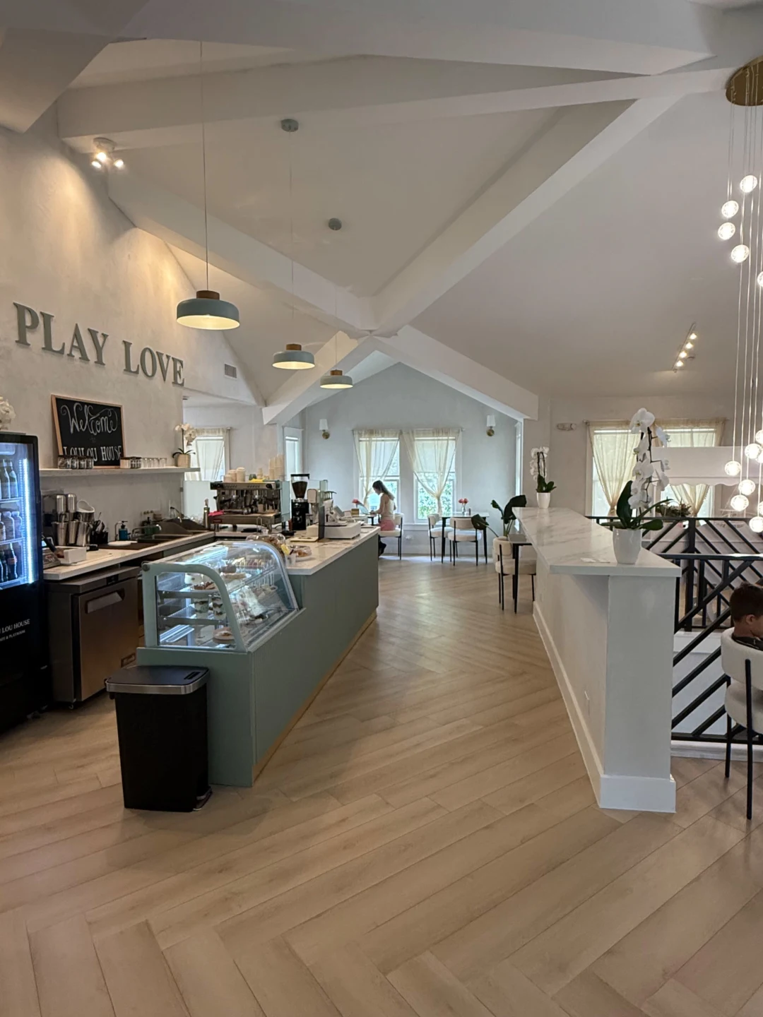 Cafe bar and pastry case under the 'Play. Love.' wall signage