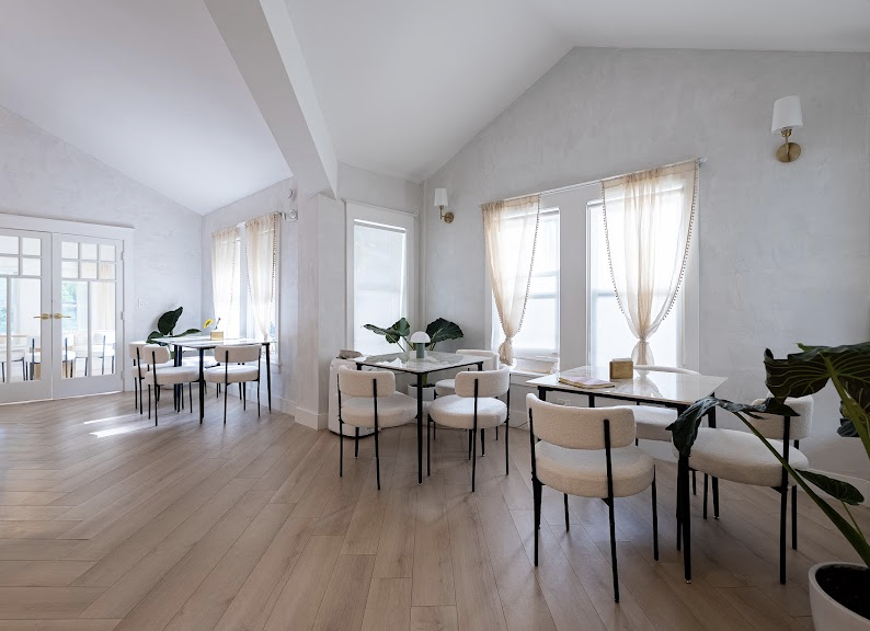 Sunlit dining area with white linen curtains and boucle chairs