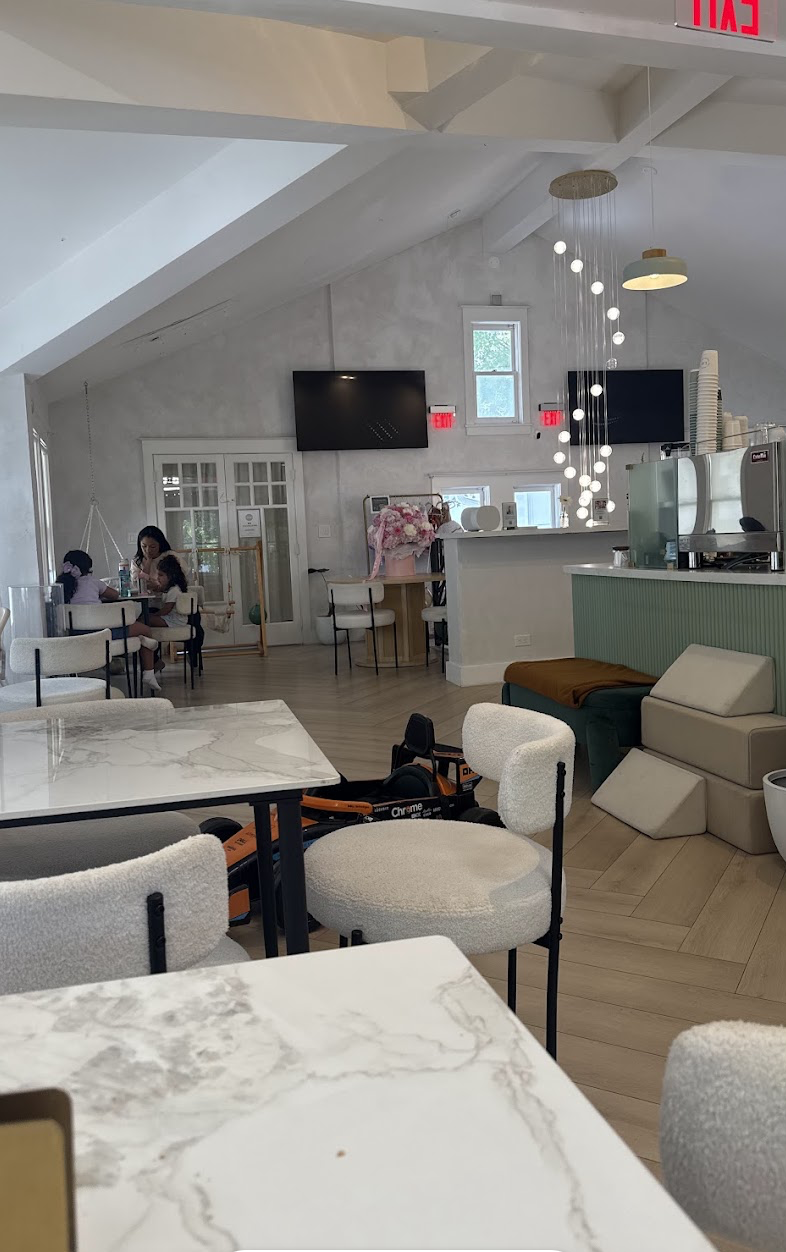 Wide view of the cafe lounge with marble tables and boucle chairs