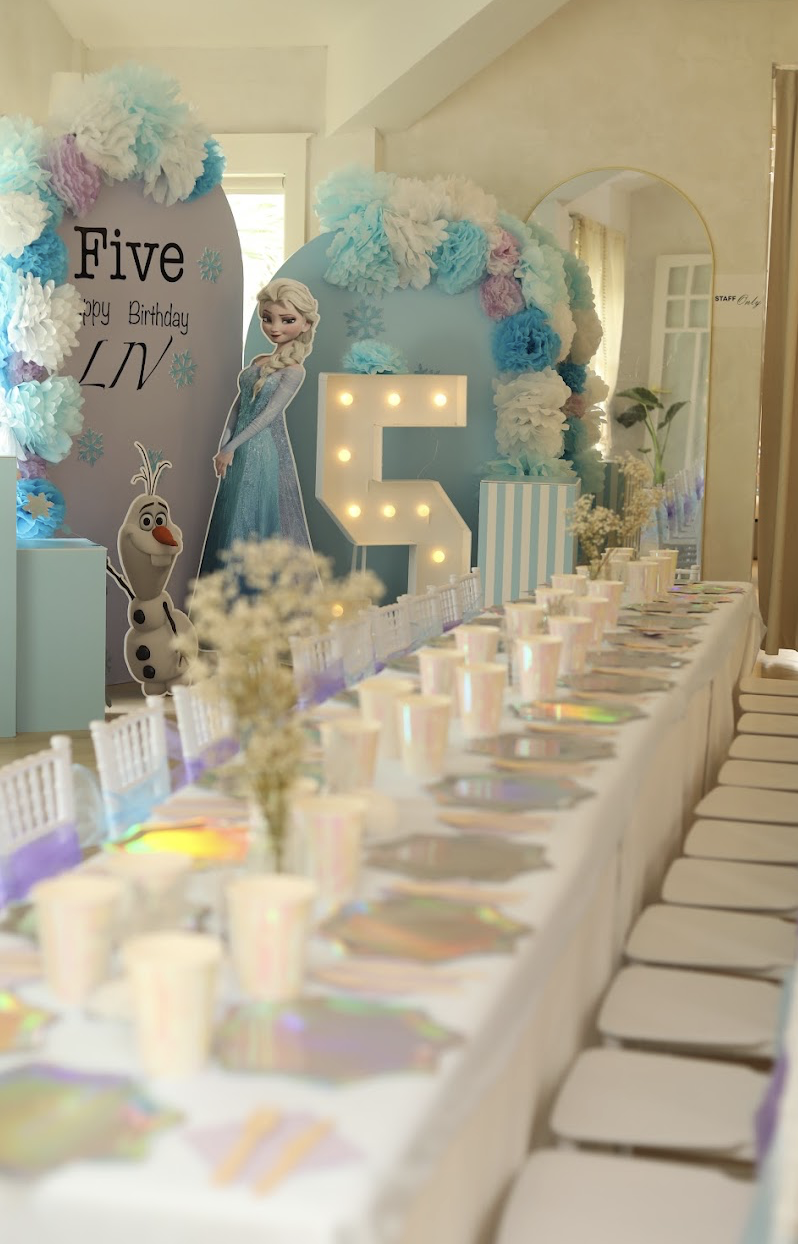 Long birthday table with Frozen theme decor and iridescent place settings at LOULOU HOUSE