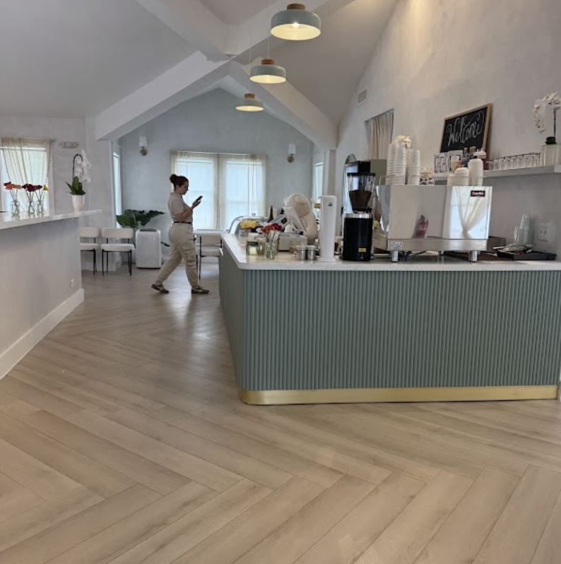Wide view of the cafe bar with sage cabinetry and herringbone floors