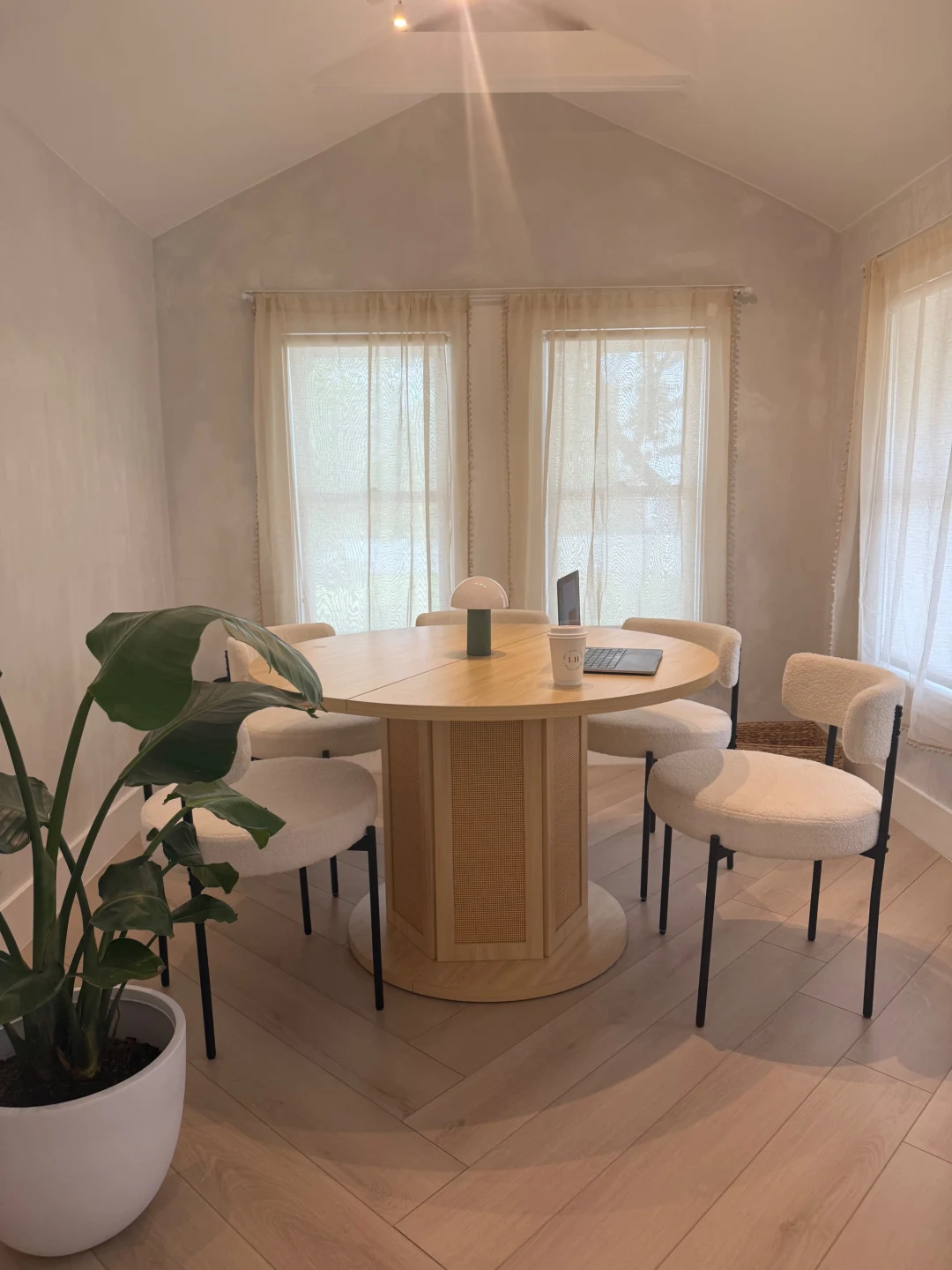 Sunlit meeting nook with round table and boucle chairs