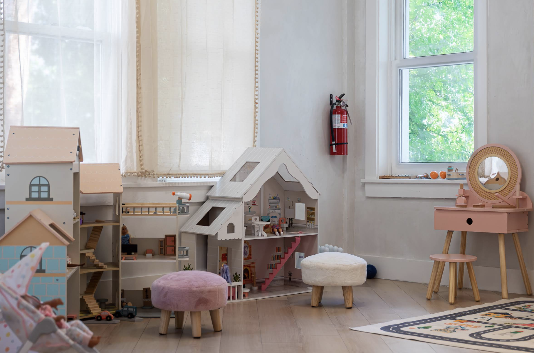 Wide view of dollhouses and play tables in the LOULOU HOUSE Play Area